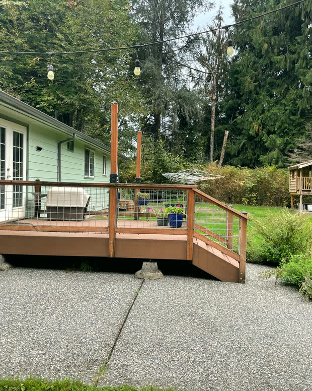 A nearer view of the deck, showing wood railing posts and gravel underfoot.