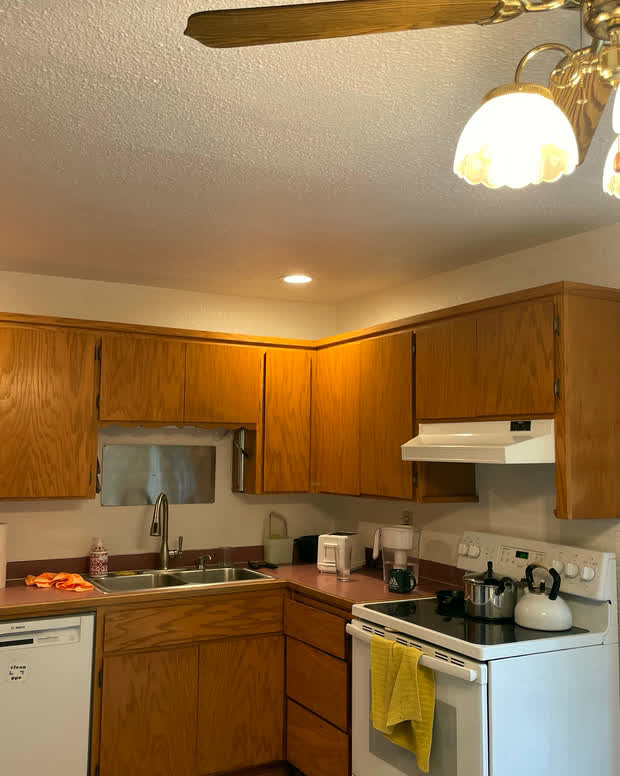 The kitchen: oak cabinets, white appliances and a window looking out to the garden.